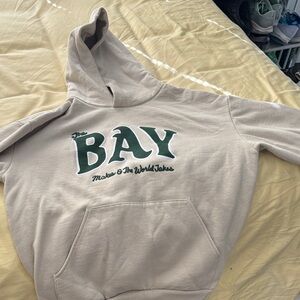 The BAY Graphic Hoodie in Light Beige with Green Logo OAKLANDISH
